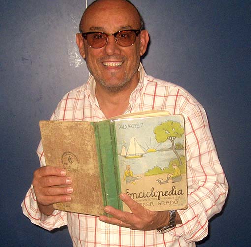 Antonio Manuel Romero, director del centro, muestra la enciclopedia original con la que él estudió