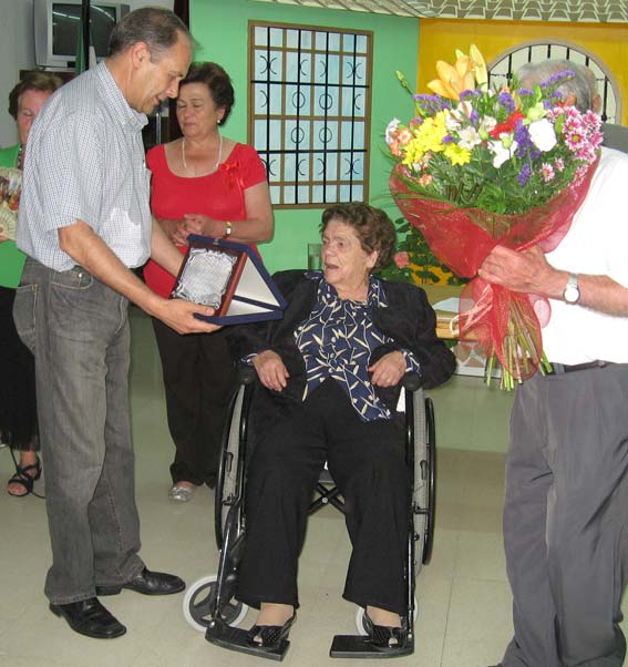  Visitación recibe la placa de manos del alcalde, y el ramo de flores del presidente del centro 